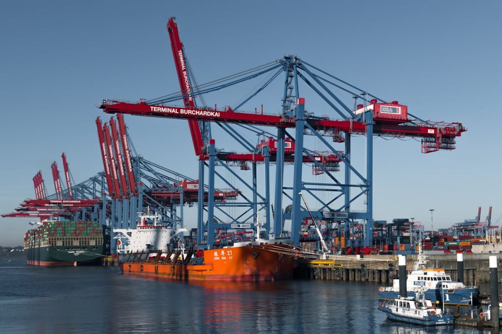 Container ships docked at Hamburgs busy Terminal Burchardkai under cranes.