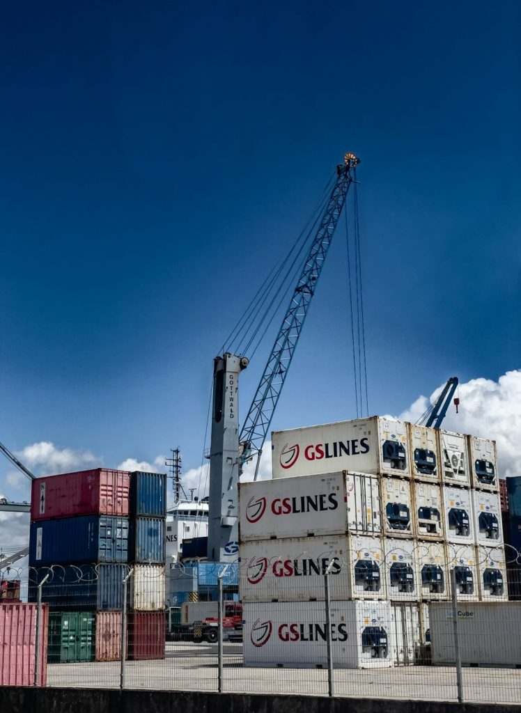 shipping-containers-stacked-at-a-port-with-a-crane-yrdb7ixqr-w